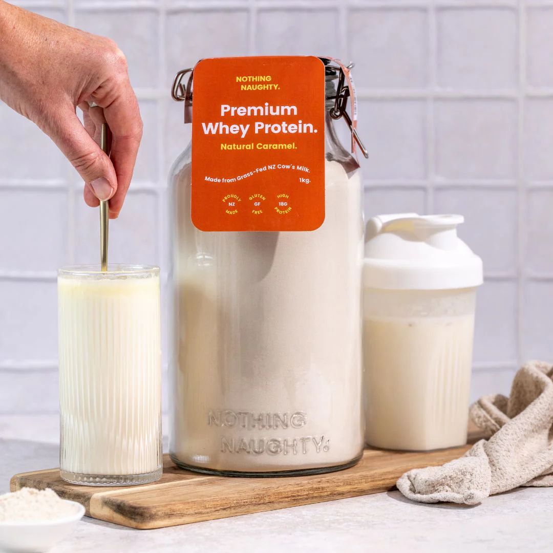 Stirring a glass of Nothing Naughty whey beside the jar